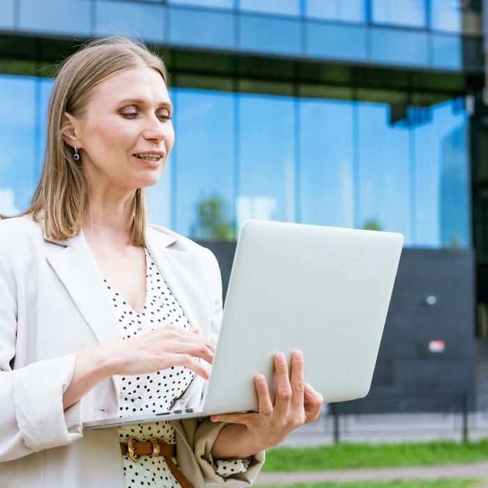 Business woman business success. Charming beautiful woman is holding a laptop